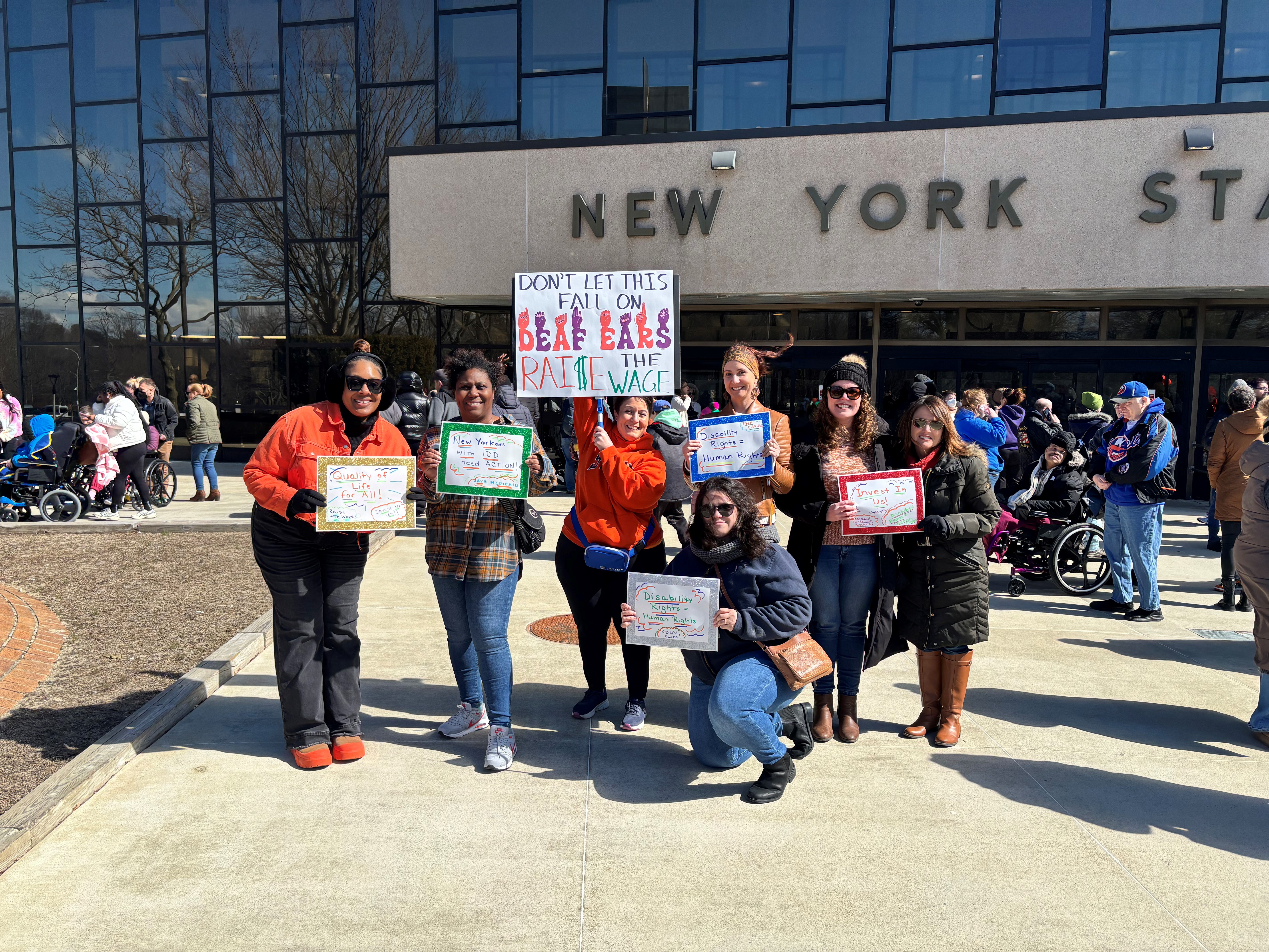 team members from Care Design New York at New York State building holding signs