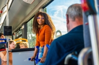 Young adult woman with crutches traveling on a city bus, looking at the camera and smiling, showing confidence and independence while using public transport