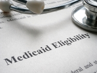 Document of Medicaid eligibility and stethoscope.
