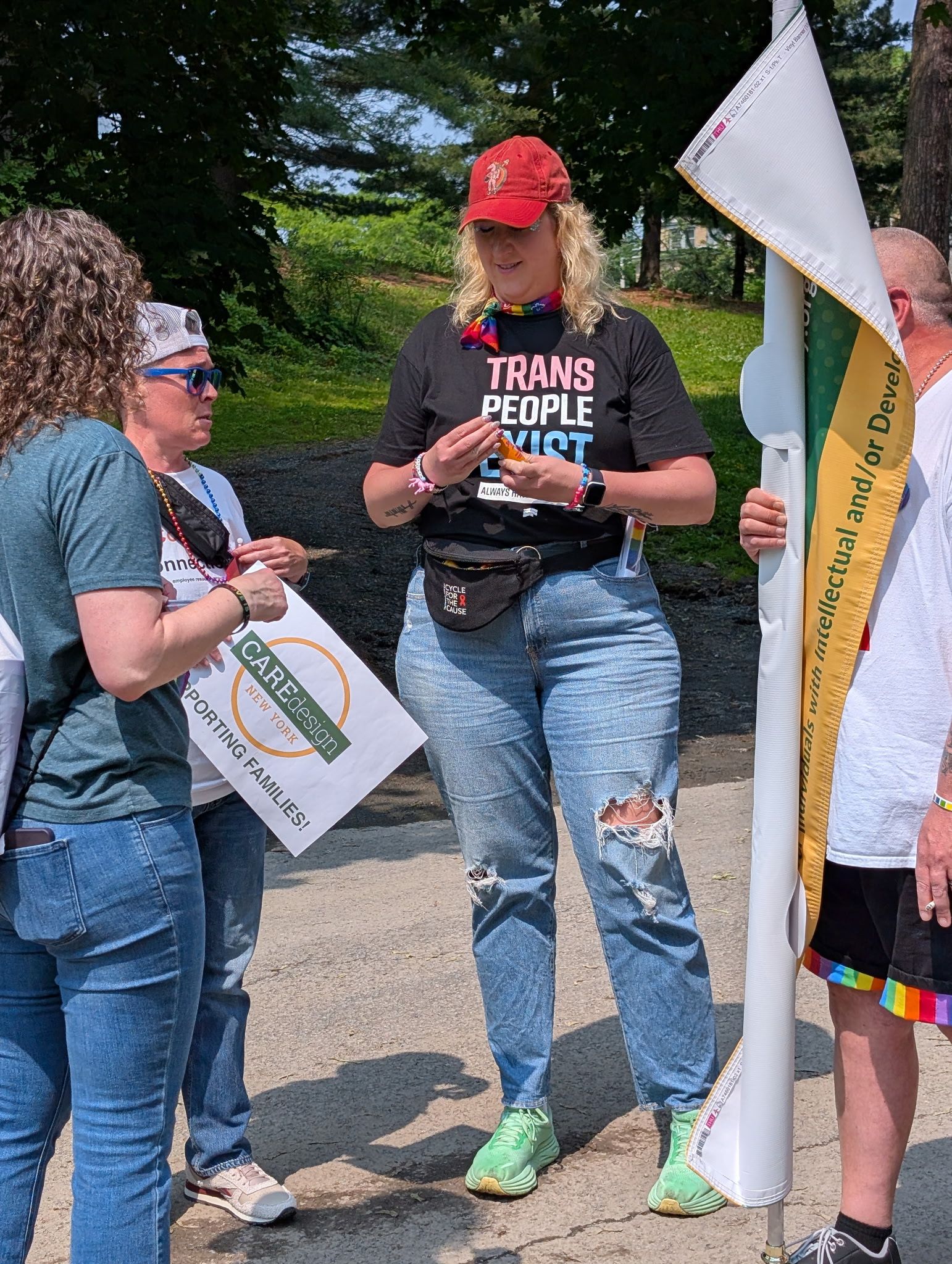 Care Design team member at parade. Woman wearing Trans People Exist shirt