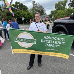 Care Design New York banner held by team member at New Paltz Pride event